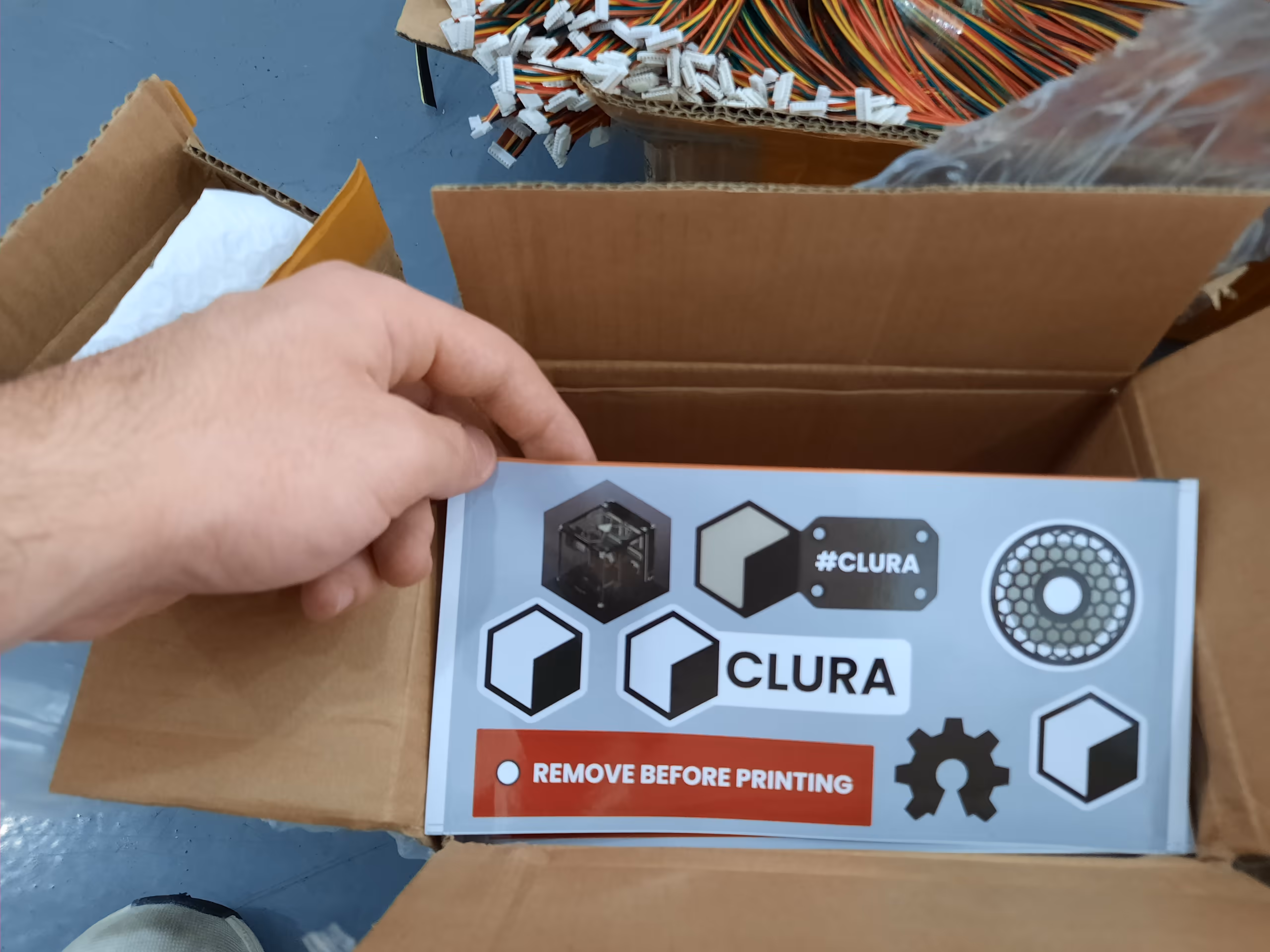 A finished Clura enclosure box held up on the factory floor